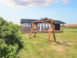 Guests can enjoy a peaceful retreat in this cabin-style building with a porch and outdoor seating area.