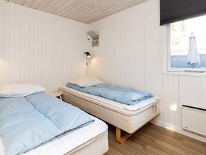 A room with two beds, a window with a view, and a wall-mounted heater. - 6 Person Holiday Home in Blokhus (Blokhus)