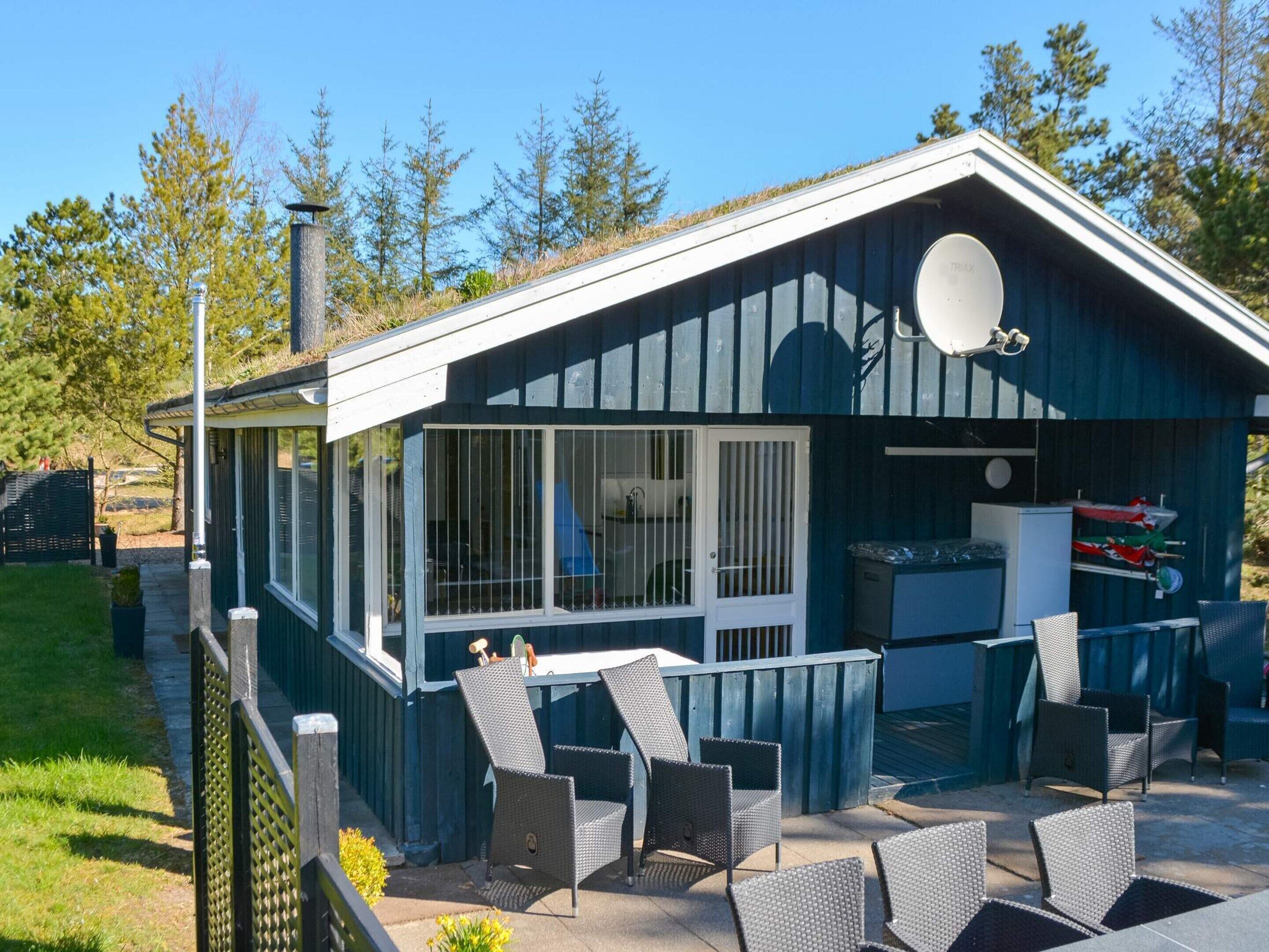 Un petit bâtiment d’un seul étage doté d’un patio couvert avec des sièges pour l’extérieur.