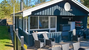 A small, single-story building with a covered patio area featuring outdoor seating. - 6 Person Holiday Home in Blokhus (Blokhus)