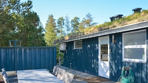 A blue building with a covered patio area, a table, and chairs. - 6 Person Holiday Home in Blokhus (Blokhus)