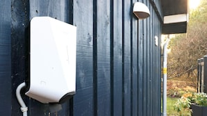 A white outdoor electrical box mounted on a dark blue wall, with a white pipe connected to it. - 6 Person Holiday Home in Blokhus (Blokhus)
