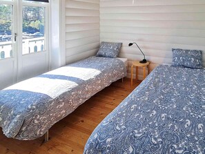 Ein Schlafzimmer mit zwei Betten, einem kleinen Tisch und einer Lampe.