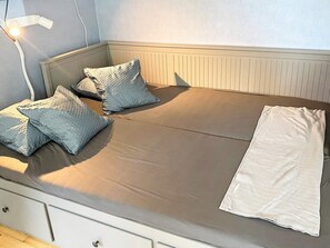 A single bed with a white mattress, two patterned pillows, and a white blanket. - 5 Person Holiday Home in Tenhult JÃ¶nkÃ¶ping (Tenhult)