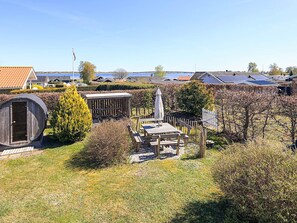 A residential area with a wooden sauna, a covered outdoor seating area, and a fenced garden. - Holiday Home in Jægerspris (Jægerspris)