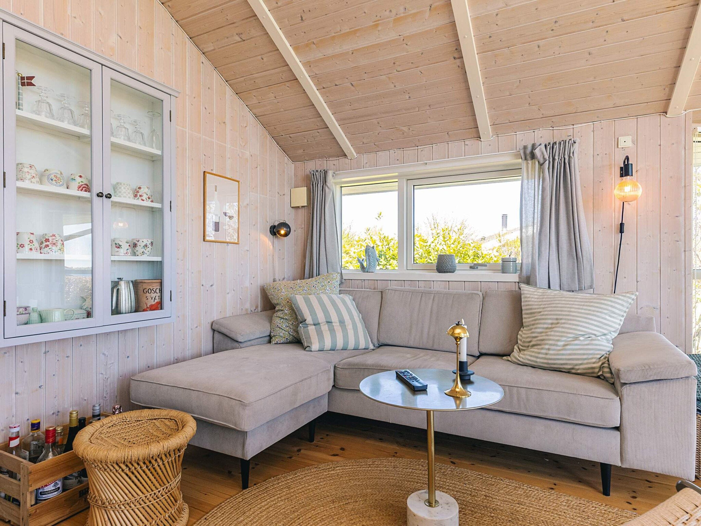 A cozy living room with a sectional sofa, a round coffee table, and a wicker chair.