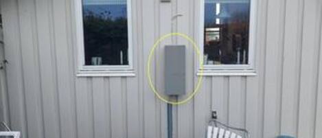 Un bâtiment d’un seul étage, doté de deux fenêtres, d’une porte et d’un coffret électrique apparent.