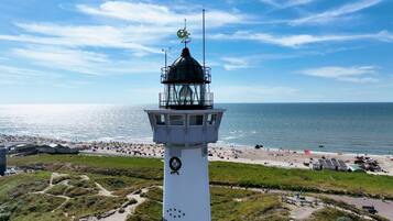 A lighthouse with a clear view of the beach and ocean.