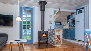 A cozy living room with a fireplace, a television, and a dining area. - 4 Person Holiday Home in Haderslev (Haderslev)