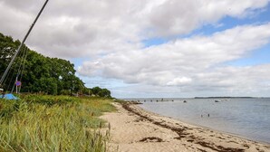 A beach with a fishing rod, a no parking sign, and a distant shoreline. - 4 Person Holiday Home in Haderslev (Haderslev)
