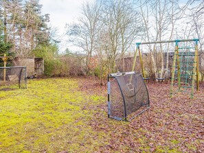 A backyard with a swing set, a climbing frame, and a fenced play area. - 6 Person Holiday Home in Ans By (Farvang)