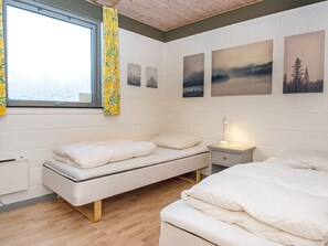A bedroom with a bed, bedside table, and a window with curtains. - 6 Person Holiday Home in Ans By (Farvang)