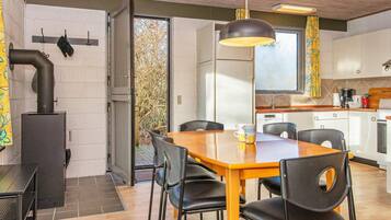 Une cuisine moderne avec un coin repas, comprenant une cuisinière, des chaises et une table.