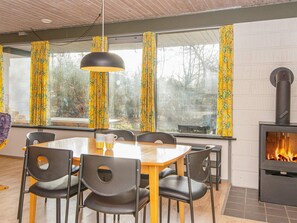 A dining area with a round table, chairs, and a fireplace. - 6 Person Holiday Home in Ans By (Farvang)