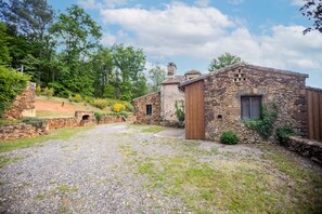 Ein Steinhaus mit Kiesweg und Holztür.