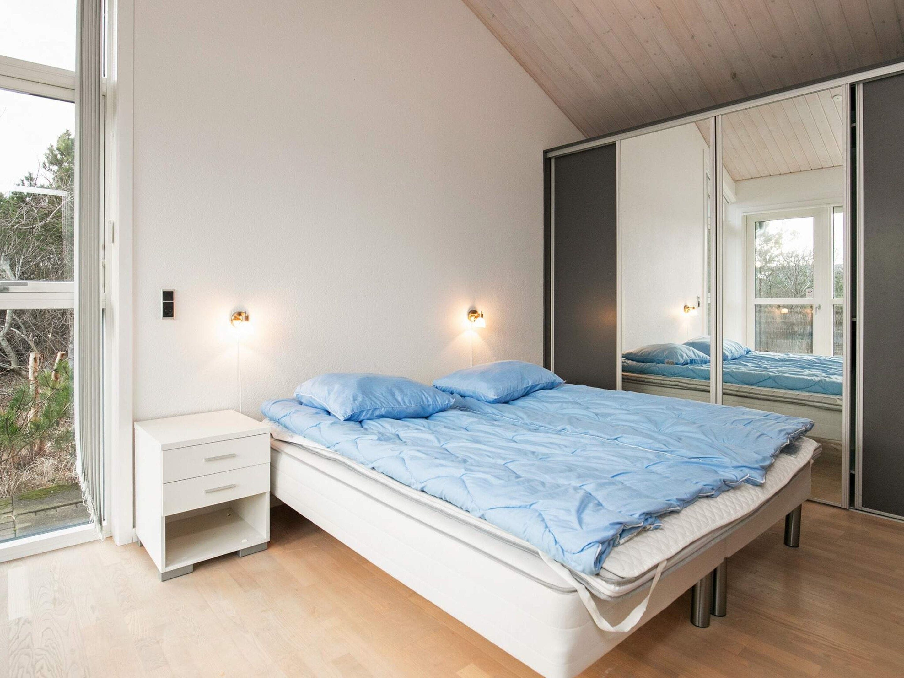 Une chambre à coucher avec un lit, une table de chevet et une armoire.
