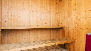 A wooden sauna with two benches and a tiled floor.