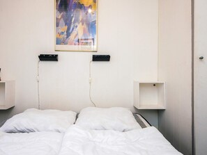 A hotel room with a bed, a painting on the wall, and two bedside tables. - 6 Person Holiday Home in Toftlund (Toftlund)