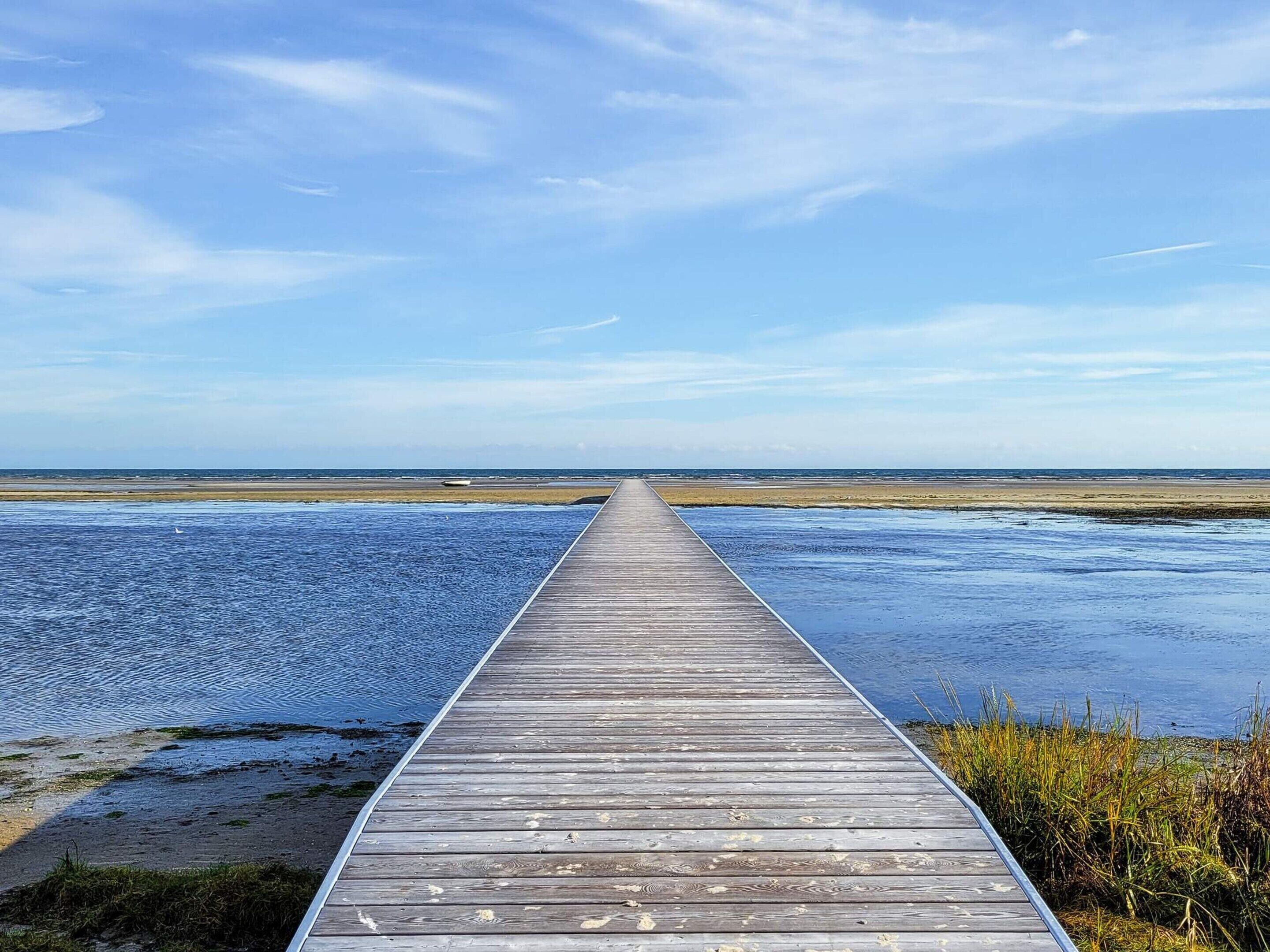 A wooden boardwalk leading to a beach.