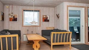 A cozy living room with a wooden table, two sofas, and a large window. - 6 Person Holiday Home in Herning (Herning)