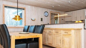 A wooden interior with a dining table, chairs, and a kitchen area. - 6 Person Holiday Home in Herning (Herning)