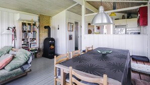 A cozy room with a fireplace, a dining table, and a bookshelf.