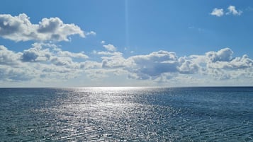 A calm sea with sunlight reflecting off the water.