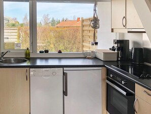 A kitchen with a dishwasher, oven, and coffee maker.