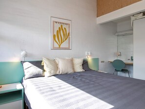 A bedroom with a bed, bedside tables, a desk with a chair, a wall-mounted mirror, and a framed artwork. - Holiday Home in VÃ¦ggerlÃ¸se (Vaeggerlose)