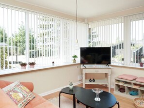 A living room with a TV, sofa, and a small table.