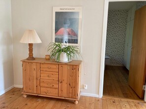 A wooden cabinet with drawers, a lamp, and a poster on the wall.