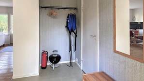 A hallway with a coat rack, a fire extinguisher, and a mirror on the wall. - 4 Person Holiday Home in Skanes-fagerhult (Skånes Fagerhult)