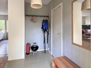 Enter a serene space with a bench, mirror, and drying rack, perfect for unpacking and preparing for a restful stay.