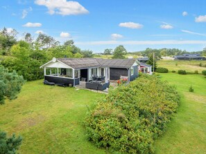 A modern house with a covered patio, a garage, and a lawn. - Holiday Home in Ebeltoft (Ebeltoft)