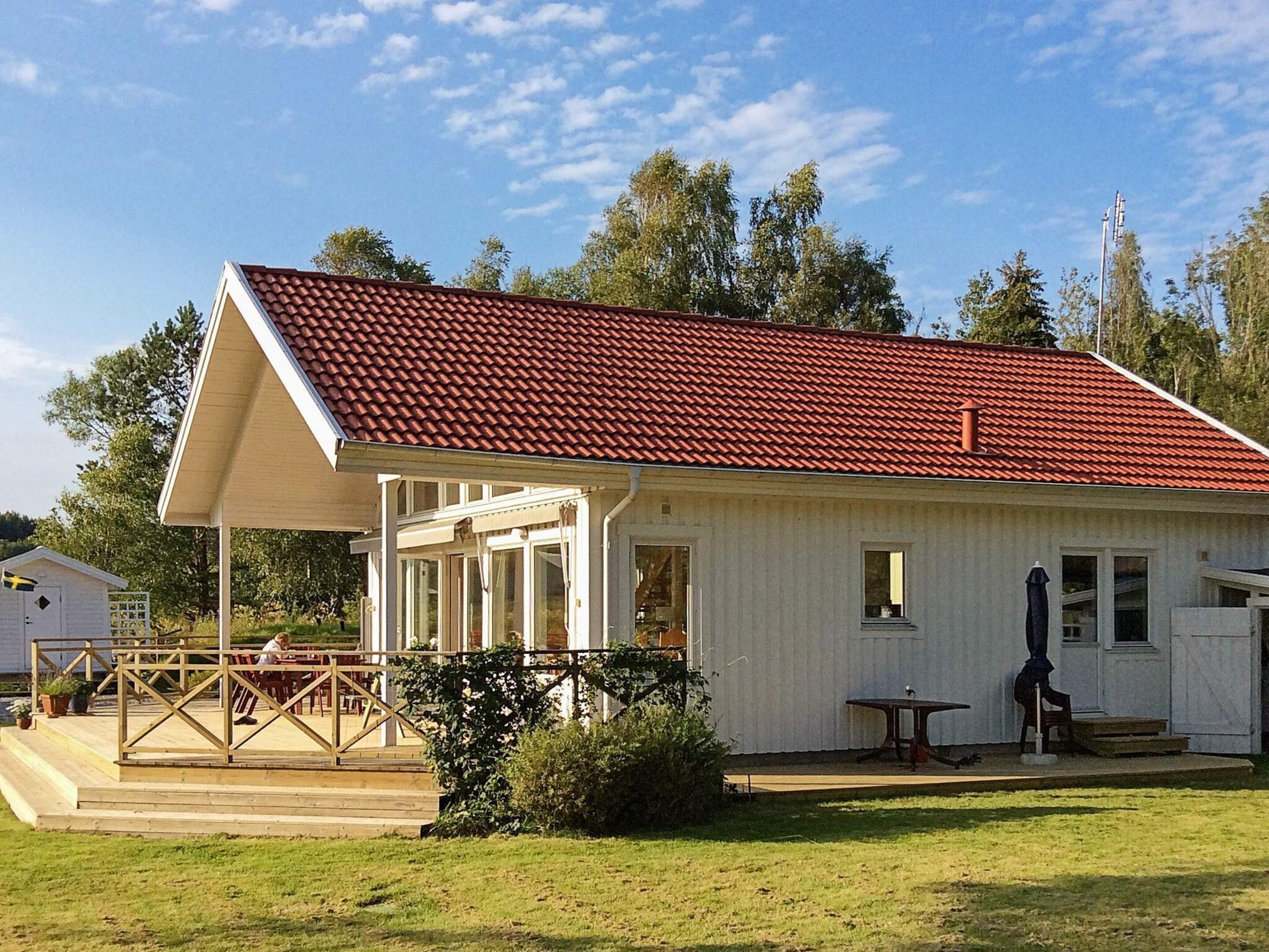 A single-story building with a red-tiled roof, a covered patio area, and a small adjacent shed.