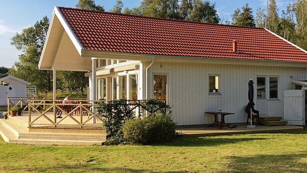 A single-story building with a red-tiled roof, a covered patio area, and a small adjacent shed. - Holiday Home in Brastad (Brastad)