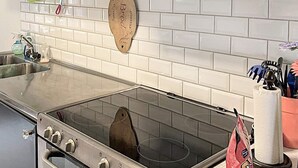 Eine Küche mit Herd, Spüle und einer Holztafel an der Wand.
