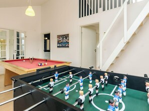 A pool table with a red felt surface and a foosball table with players in blue and white uniforms. - Holiday Home in Hadsund (Hadsund)