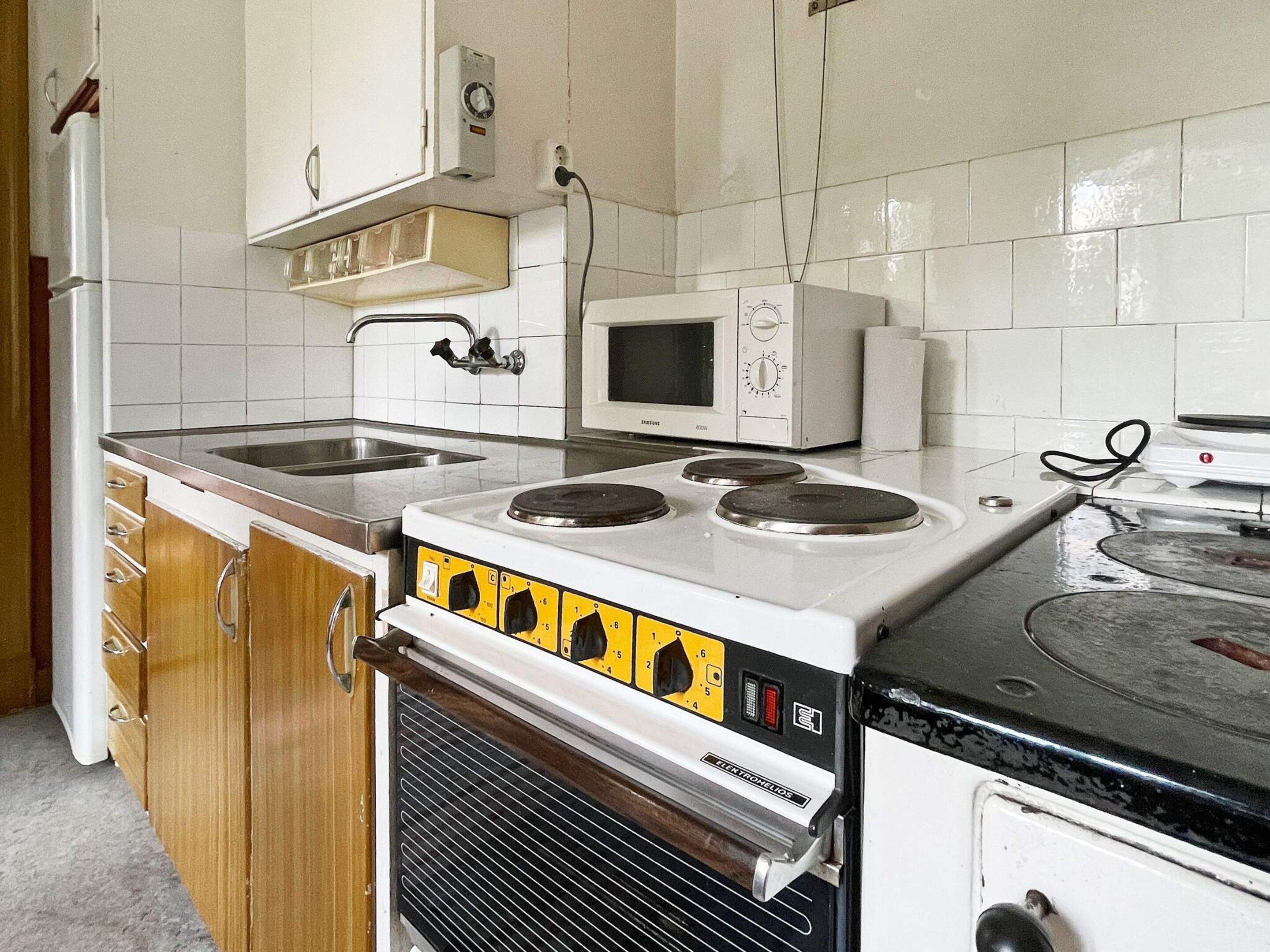 A kitchen with a stove, microwave, and sink.