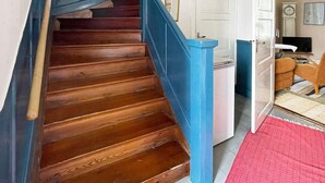 A wooden staircase with blue handrails leading to a white door. - 5 Person Holiday Home in Linneryd/kronobergs Lan (Linneryd)