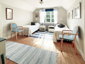 A bedroom with two single beds, a desk, a chair, a radiator, and a window with curtains. - 5 Person Holiday Home in Linneryd/kronobergs Lan (Linneryd)
