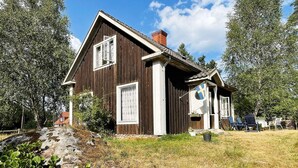 A wooden house with a sloped roof, a chimney, and a flag. - 5 Person Holiday Home in Linneryd/kronobergs Lan (Linneryd)