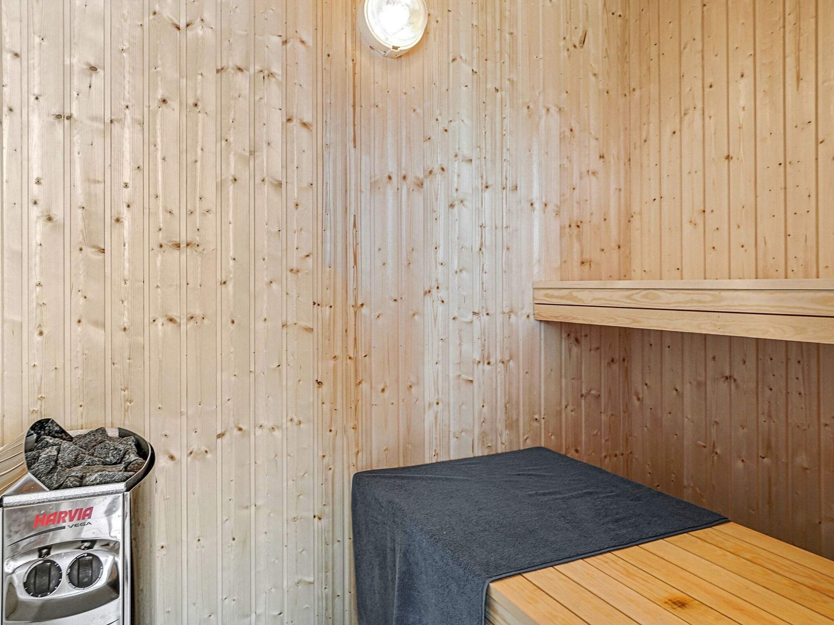 Een sauna met houten wanden, een bank en een sauna-oven.