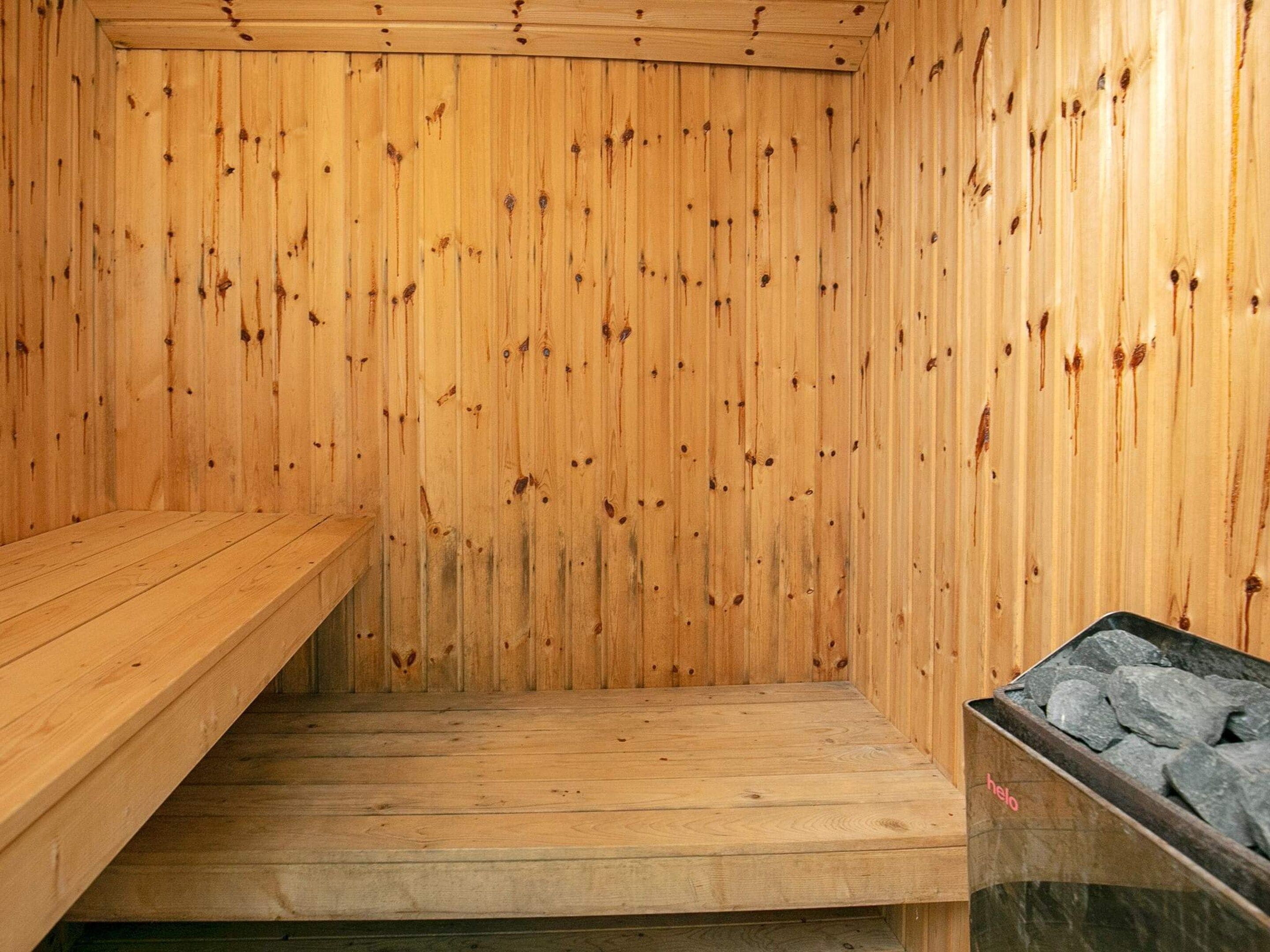A sauna room with wooden walls and benches.