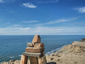 A stack of stones by the sea with a clear view of the ocean.