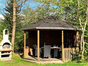 A wooden gazebo with a pitched roof, surrounded by trees. - Holiday Home in Gilleleje (Gilleleje)