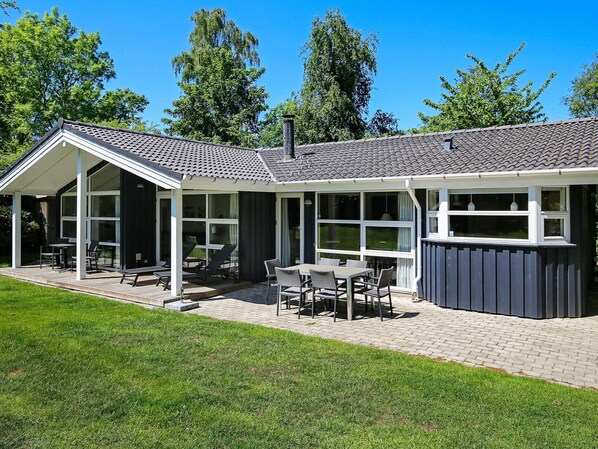 A modern house with a covered patio, large windows, and a brick pathway. - Holiday Home in Gilleleje (Gilleleje)