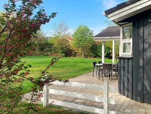 A patio with outdoor furniture, a covered seating area, and a view of a grassy yard. - Holiday Home in Gilleleje (Gilleleje)