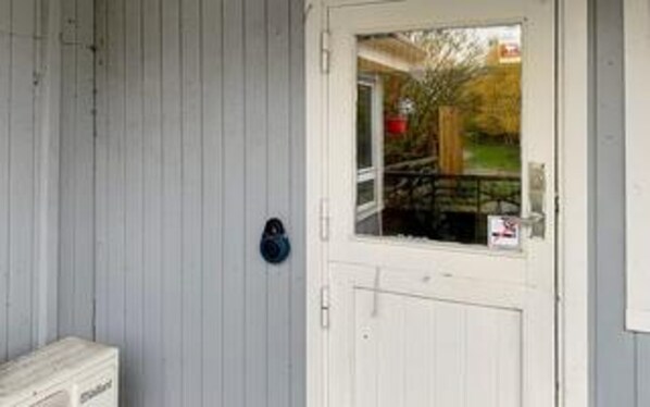 A white door with a window, a mailbox, and a small outdoor area with a fence. - 4 Person Holiday Home in Store Fuglede (Store Fuglede)