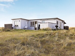 A single-story house with a flat roof, a front door, and a small porch area.